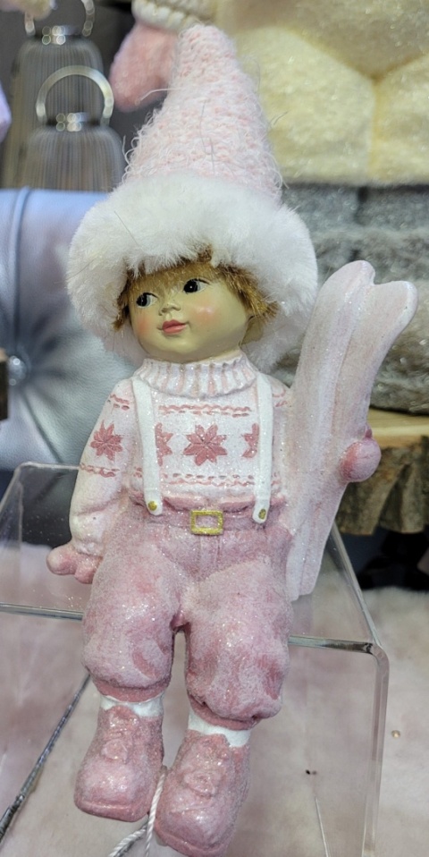 Chłopiec ceram. siedzący z nartami różowy (NB0549) h:21*8*7cm
