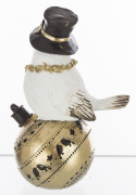 Ptaszek biały w czarnym kapeluszu na złotej bombce (159523)